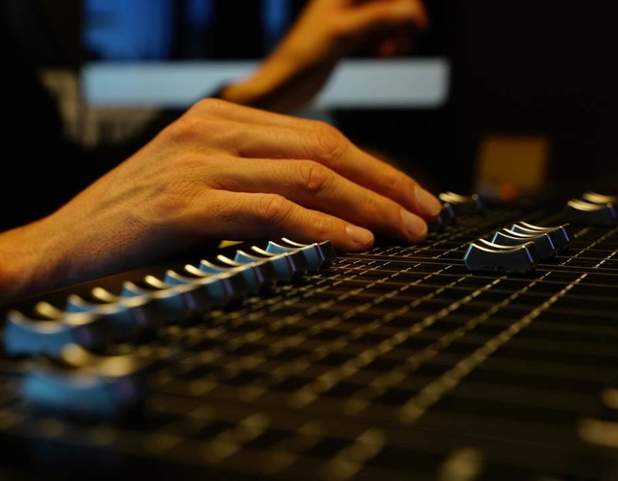 Hand aan een digitale mengtafel tijdens een show